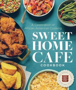 Sweet Home Cafe Cookbook cover, with fried chicken, macaroni and cheese, bean salads on display from above on a teal tablecloth.